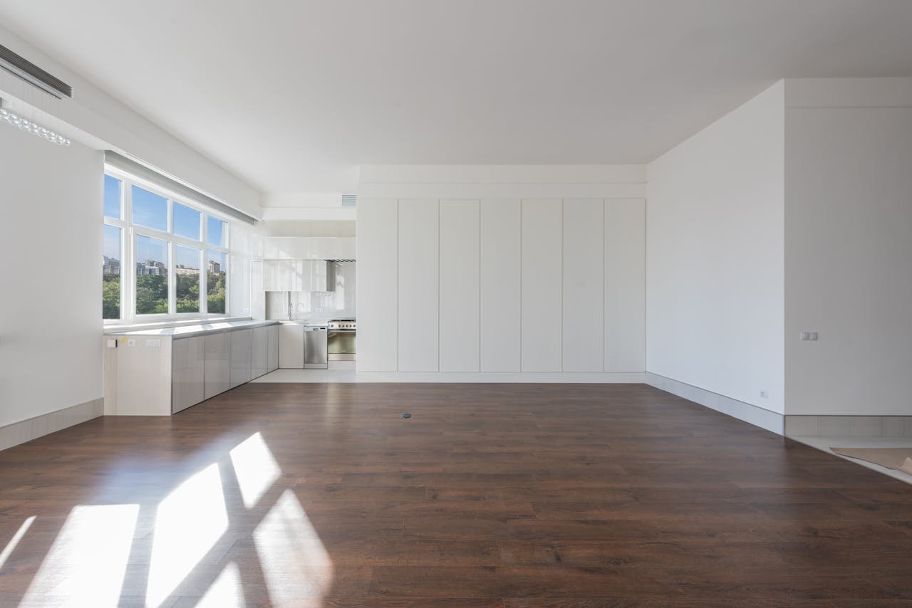 Bright and spacious modern kitchen interior featuring wooden floors and white cabinetry. Bright and spacious modern kitchen interior featuring wooden floors and white cabinetry.